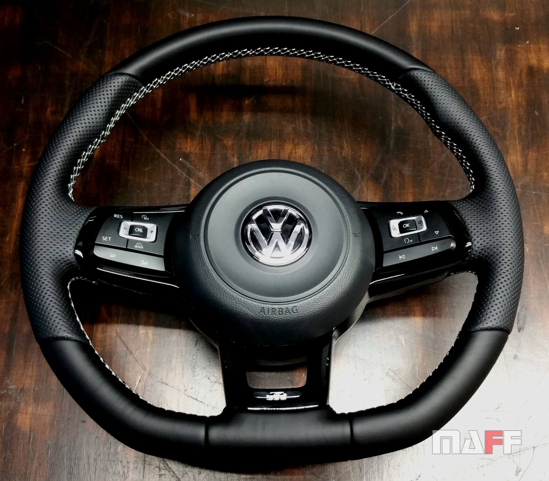 Zdemontowana kierownica Volkswagen Golf 7 R po obszyciu skórą, ułożona na blacie roboczym